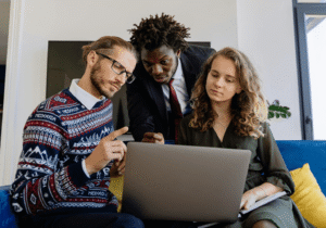 Trois collaborateurs travaillant ensemble sur un ordinateur portable pour lancer un projet business
